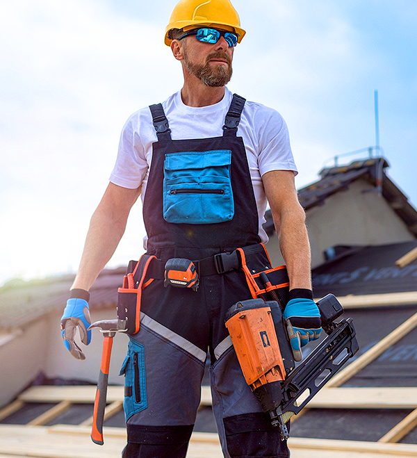Roofer on rooftop with tools